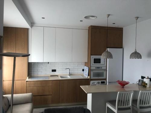 科尔多瓦ENMAYO 2021 - Dos alojamientos的厨房配有白色橱柜和桌椅