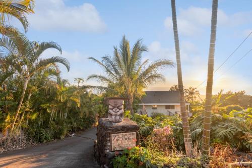 科纳Charming Pu'ukala Sunset - Near Hiking and Golf home的一条有棕榈树的道路和一座建筑