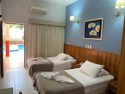 恩卡纳西翁Terwindt Hotel的两张位于酒店客房的床,拥有蓝色的墙壁