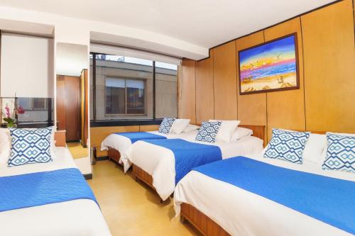 通哈Hotel San Francisco的一间设有三张床的客房,配有蓝色和白色的床单