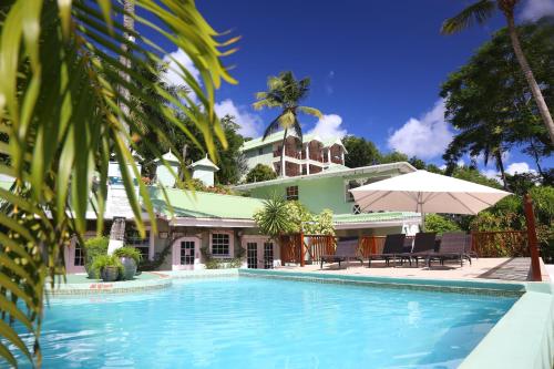 马里戈特湾马里戈海滩俱乐部潜水度假酒店的一座房子前面设有游泳池