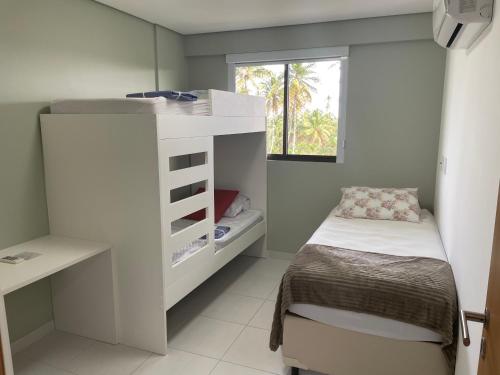 伊波茹卡Flat Confort Pé na Areia的一间小卧室,配有一张小床和一个窗户