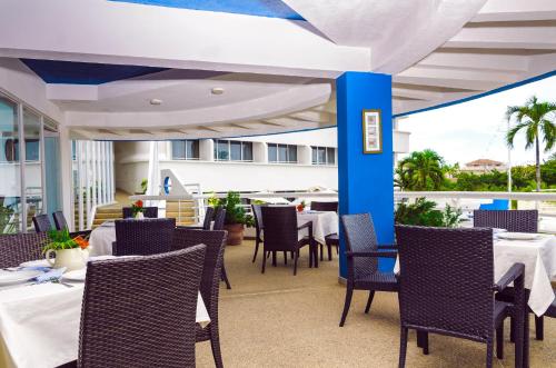 PampatarAquarius Hotel Boutique的庭院内带桌椅的用餐室