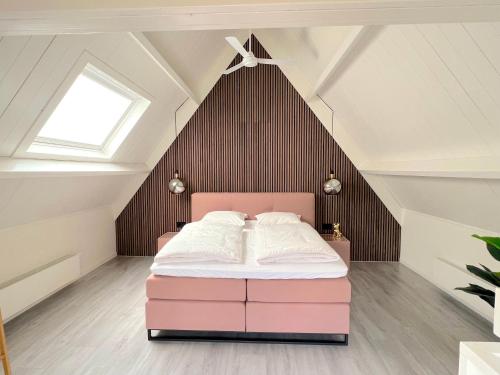 弗利辛恩Thuishaven的阁楼卧室配有粉红色的床