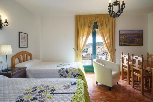 鲁伊德拉Doña Ruidera的一间卧室设有两张床、一把椅子和一个窗户。