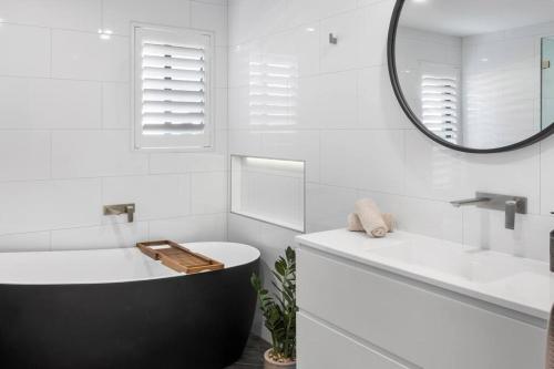 贝尔蒙特Rengor Executive Retreat的带浴缸、水槽和镜子的浴室
