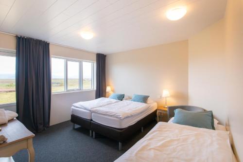 Hólmabæir达斯赛尔农场住宿加早餐旅馆的酒店客房设有两张床和窗户。