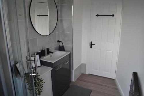 利兹Luxury Home Close to Leeds City Centre的一间带水槽和镜子的浴室