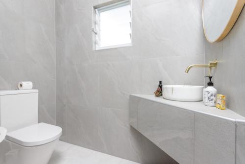 拉罗汤加Studio Varia的白色的浴室设有水槽和卫生间。