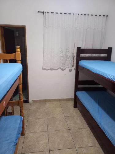 大普拉亚Casa em Praia Grande -SP的客房设有两张双层床和一扇窗户。