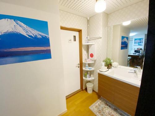 德岛Reinahill - Vacation STAY 67171v的浴室配有水槽,墙上挂有山画