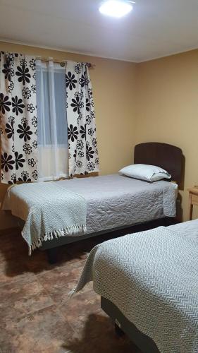 圣佩德罗·德·阿塔卡马Rincon del Inca的一间卧室设有两张床和窗户。