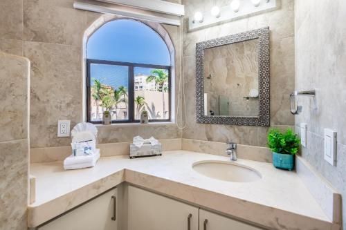 卡波圣卢卡斯Marina Cabo Plaza Town & Beach Condos的一间带水槽和镜子的浴室