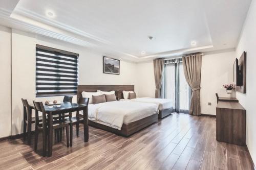 芽庄La Sera Suites Nha Trang的一间卧室配有一张床、一张桌子和一张书桌