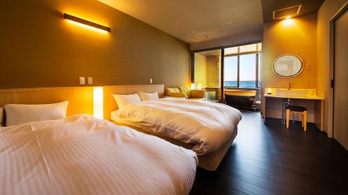 萩市リゾートホテル美萩的酒店客房,设有两张床和镜子