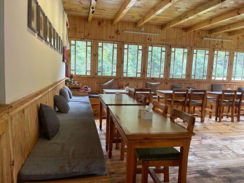 PhakdingKongde Peak Guest House的用餐室设有桌椅和窗户。
