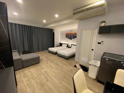 暖武里府Bangyai Inn的客厅配有床和沙发