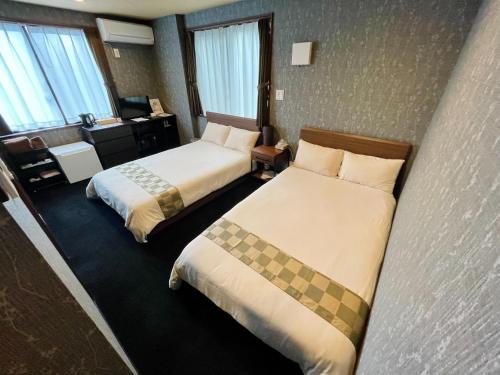 成田NARITA HOTEL KAKUREGA - Vacation STAY 69221v的酒店客房配有两张床和一张书桌