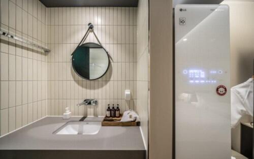 釜山Brown Dot Hotel Sajik Baseball Stadium的一间带水槽和镜子的浴室