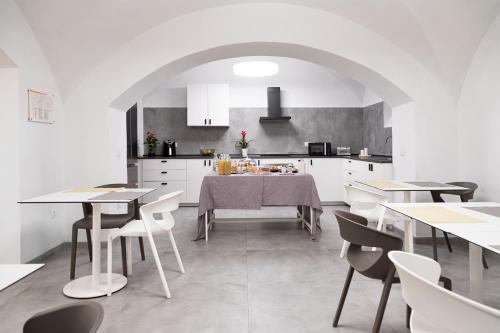 博洛尼亚Bohoostel的厨房以及带白色橱柜和桌子的用餐室。