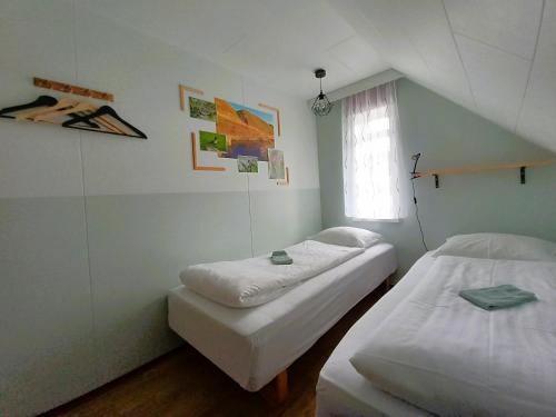 胡萨维克Húsavík Green Hostel的小型客房 - 带2张床和窗户