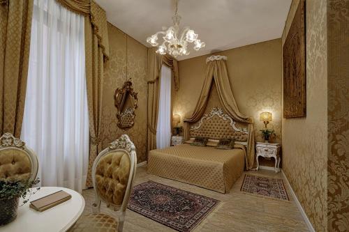 威尼斯卡朋韦奇尼B&B酒店的一间卧室配有一张床、一张桌子和一个吊灯。