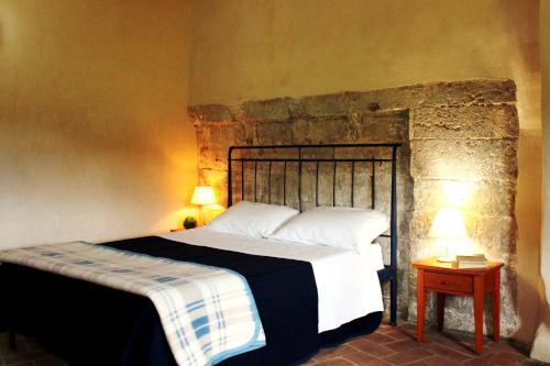 蒙特里久尼Ostello Contessa Ava dei Lambardi的一间卧室设有一张床和石墙