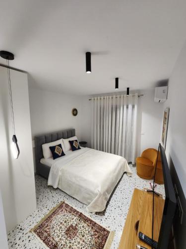 地拉那Pietro Guesthouse 3的一间白色卧室,配有床和电视