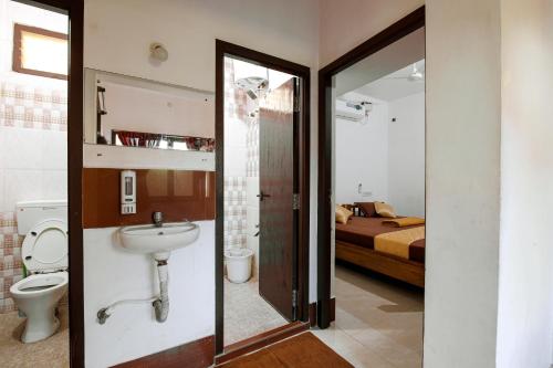 蓬蒂切里Manora Residency的一间带水槽和卫生间的浴室以及一张床
