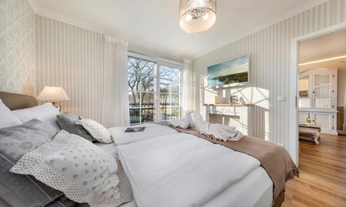 青斯特Villa Strandblick Zingst的卧室设有一张白色大床和一扇窗户。