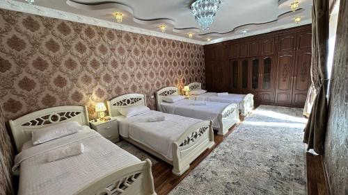 撒马尔罕OLD STREET Guest House的一间卧室设有四张床和吊灯。