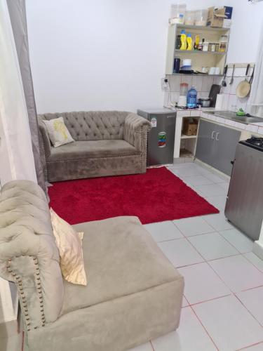 蒙巴萨ADIA APARTMENTS的带沙发和红色地毯的客厅