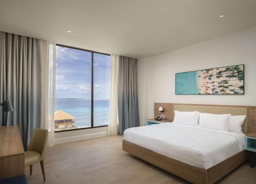 拉罗马纳Hilton Garden Inn La Romana的一间卧室配有一张床,享有海景