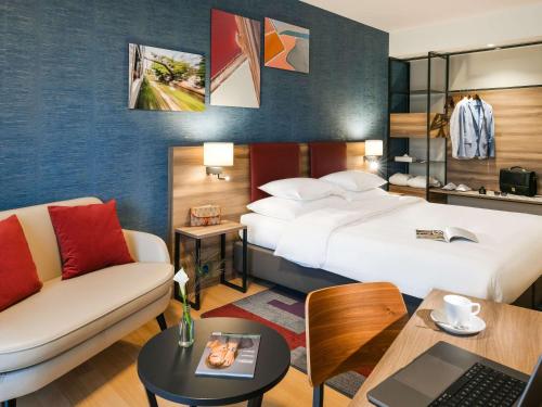 日内瓦Mercure Geneva Airport的酒店客房,设有两张床和一张沙发