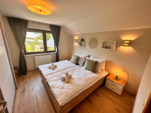 布莱德Vila Minka Bled - Perfect Family Vacation Home的一间卧室配有一张带两张蜡烛的床。
