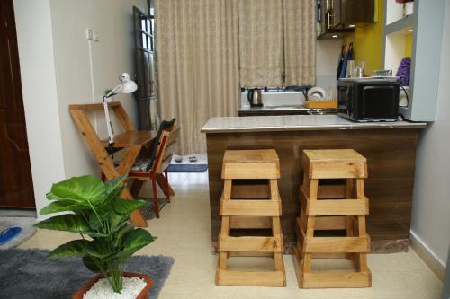 BungomaEnZ 6 lovely Apartments的厨房配有柜台和一些木凳