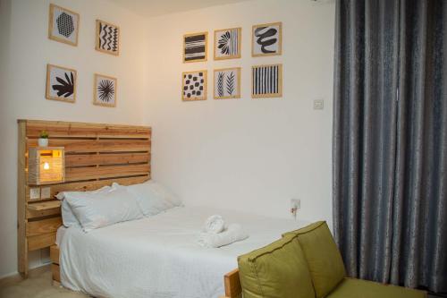 BungomaEnZ 6 lovely Apartments的一间卧室配有一张床和一把椅子,墙上挂着图片