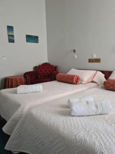 伊兹拉Greco Hotel的两张睡床彼此相邻,位于一个房间里
