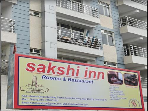 瓜廖尔Hotel Sakshi Inn Rooms and Restaurant的公寓大楼前的标志