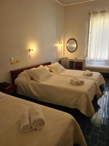 伊兹拉Greco Hotel的两张位于酒店客房的床,配有毛巾