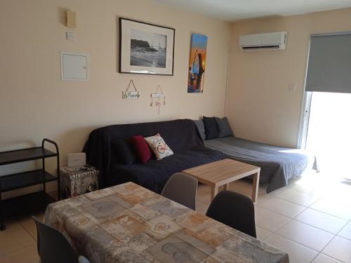 XylophaghouXylophagou Larnaca Ayia Napa 1 bedroom apartment的客厅配有沙发和桌子