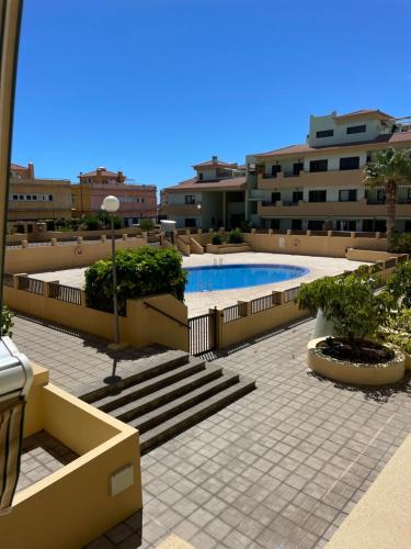 圭马尔港Apartamento La Marquesa Beach的庭院,设有游泳池和部分建筑