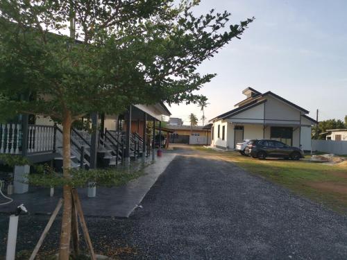 瓜拉丁加奴Anjung Barakah Chalet的树旁有停车位的建筑物
