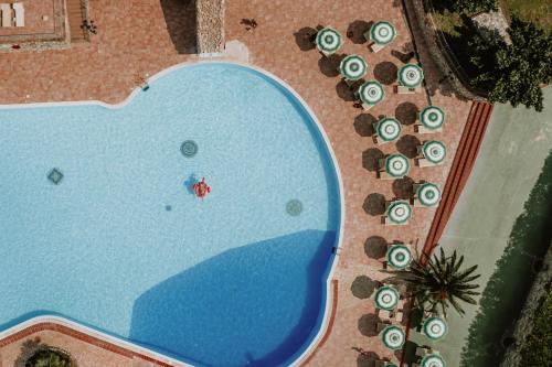 里帕尔贝拉Borgo San Pecoraio Resort的享有带躺椅的游泳池的顶部景致