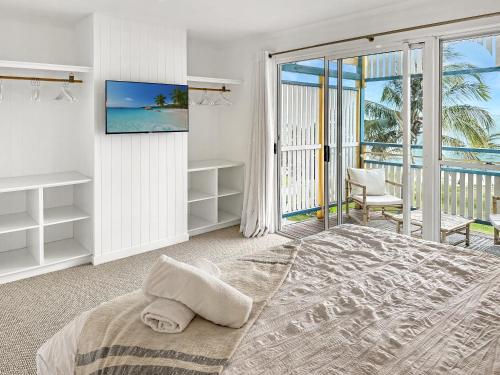 天阁露玛Paradise Palms Tangalooma的一间卧室设有一张带电视的床和一个阳台。