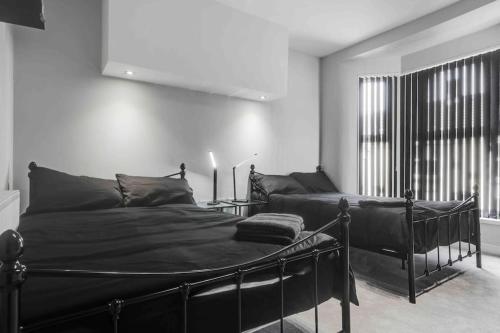 利物浦4 bedroom stylish home central location的一间卧室设有一张黑色的床和一个窗户。