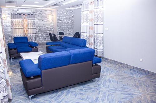 洛美Grand appartement lomé centre ville mer clim 6pers的一间配备有蓝色沙发和椅子的等候室