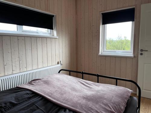 ÁsólfsstaðirÁsólfsstaðir - Miðhóll的一间卧室设有一张床和两个窗户。