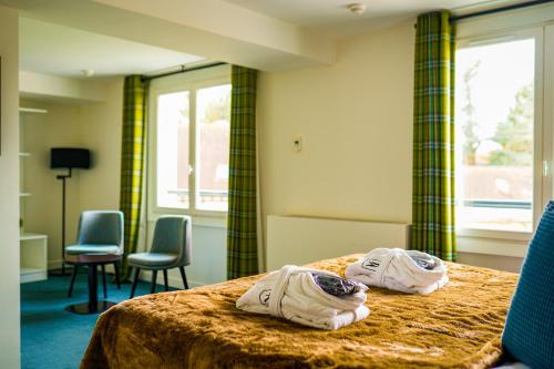 厄尔河畔帕西Hôtel-Restaurant Bel Ami的酒店客房,配有两张带毛巾的床