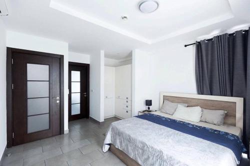 阿克拉Labone Luxury Condo and Apartment in Accra - FiveHills homes的一间白色客房内配有一张大床的卧室